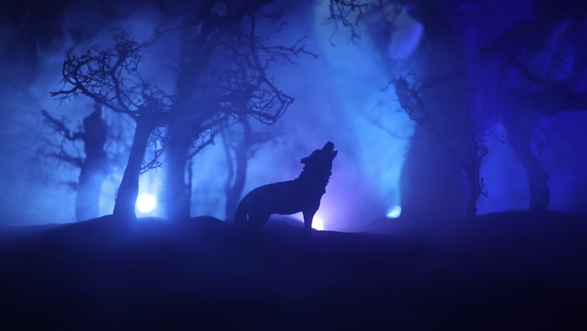 Silhouette of howling wolf against dead forest skyline and full moon. Creative artwork decoration. Selective focus | Shutterstock HD Video #1066668337