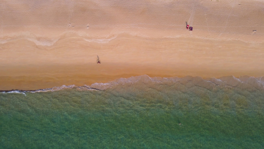Aerial view drone over beach sea. Camera move follow bicycle on beach sand and shadow on sand. Summer sunset seascape. Phuket Thailand Beach. Water texture. Top view of the fantastic natural sunsets Royalty-Free Stock Footage #1066684018
