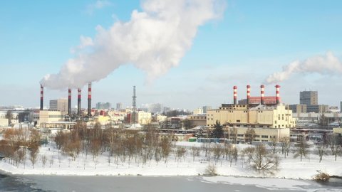In the winter city, the factory's chimneys are smoking. The concept of air pollution. Environmental pollution by industrial waste