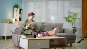 work in quarantine, young business woman in jacket and pajama pants is working remotely talking to head of office via video link on laptop while man in headphones vacuums room - Powered by Shutterstock - Get 15% off with code: PIKWIZARD15