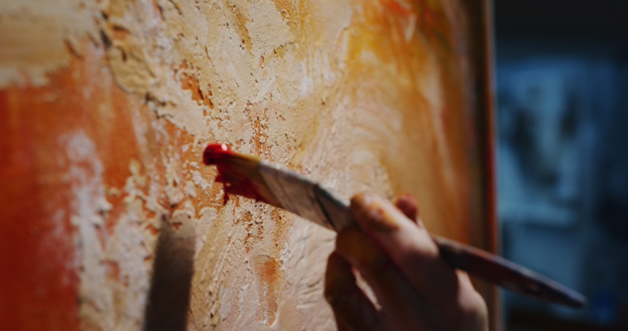 Cinematic macro shot of female creative artist painter concentrated and inspired painting abstract picture with paint brush and oil colors on canvas while working on new masterpiece for exhibition. Royalty-Free Stock Footage #1066696963