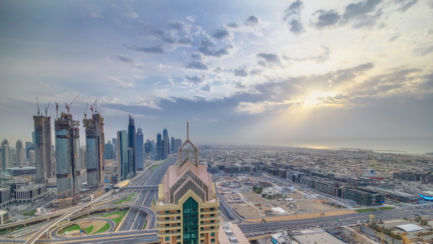 Dubai downtown skyline timelapse at sunset with beautiful city center skyscrapers and Sheikh Zayed road traffic on junction. Top aerial view from tower rooftop. Clouds on the sky. Dubai, United Arab | Shutterstock HD Video #1066701763