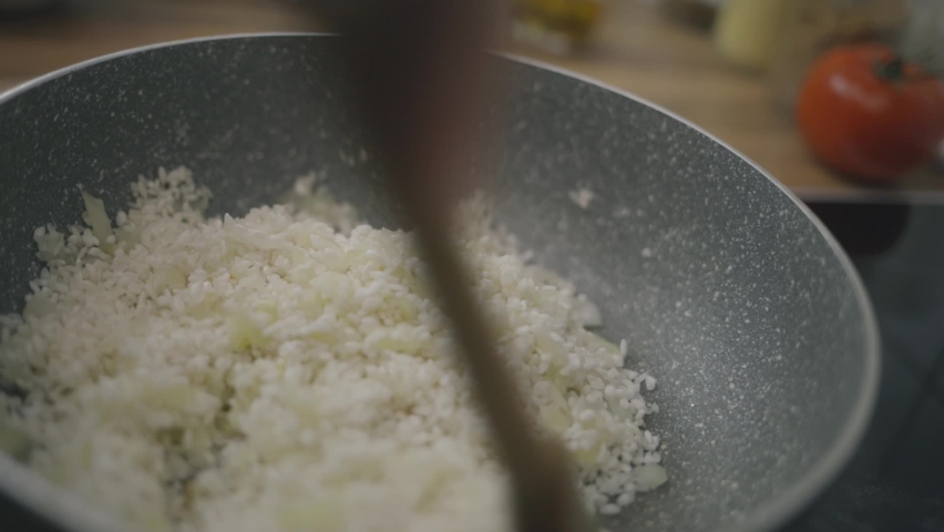 Chef cooking onions and rice in a pan | Shutterstock HD Video #1066708873