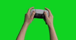 Teenager using gamepad wireless controller pressing keys and sticks and playing competitive action shooter console games. Isolated chroma key background.