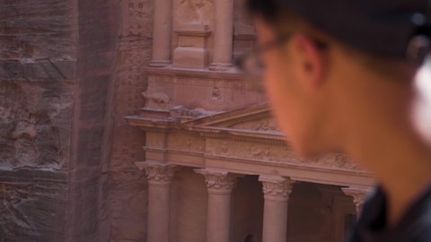 Man look into The Treasury ancient building in Petra Jordan. Close up shot.