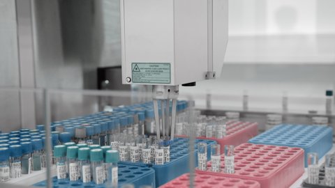 Automated production of vaccines and medicines, development and testing in laboratory, covid-19 vaccine trials, concept. Test tubes on pharmaceutical conveyor, sorting with modern robotic technology