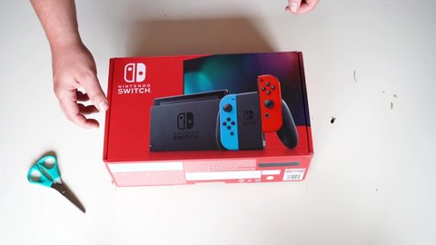 02.02.2021 - Italy, florence. a Person who unboxes a package, with a Nintendo Switch game inside the Nintendo labo. a portable console to play you have video game