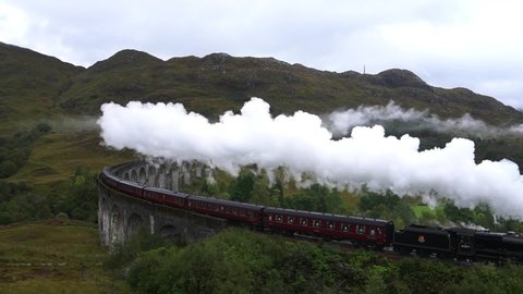 Steam Train crosses the Glenfinnan viaduct in the Scottish Highlands leaving a long trail of smoke