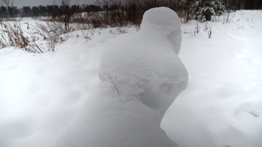 ice figure, wind and snow created a snow figure that looks like a sitting girl