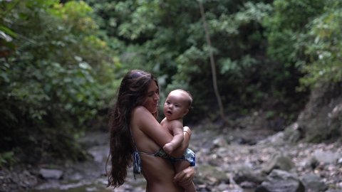 Woman playing with her baby son in a natural setting in Costa Rica