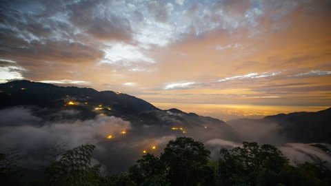 Time lapse of a mountain landscape in Taiwan as twilight turns to night and the stars appear. Lights of a town can be seen in the distance.