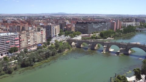 Aerial view of Zaragoza cityscape and stone bridge over Ebro river fro