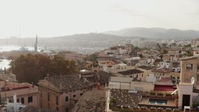 Waterfront of the city on the Mediterranean sea dron 4K video. Aerial view Downtown with houses with roofs and beautiful architecture and streets on the coastline in Palma Spain.