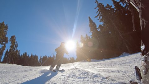 Professional skier skiing on slopes on beautiful sunny day, slow motion