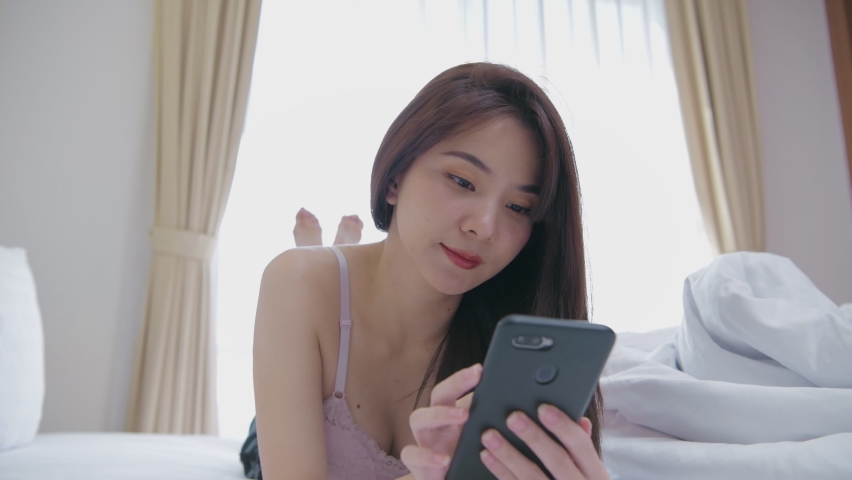 Holiday concept of 4k Resolution. Asian girls playing cell phones in the bedroom.