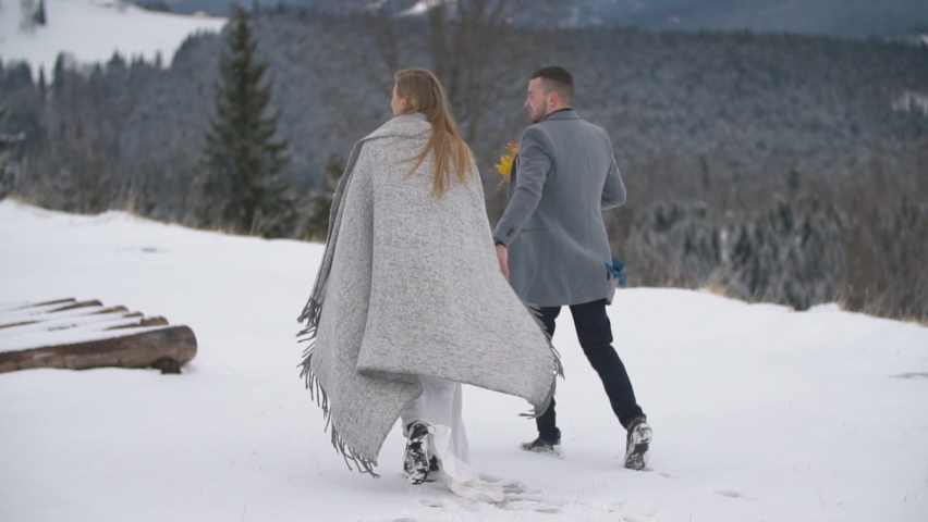 young couple walking in the winter forest.