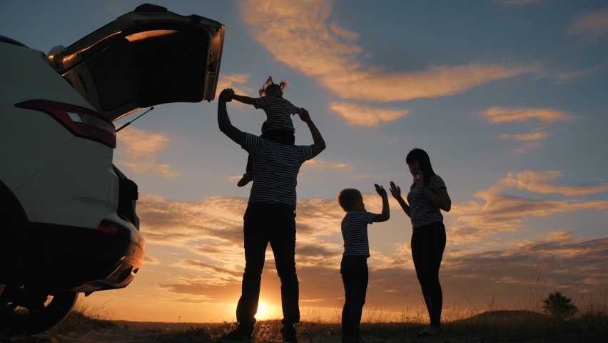 Happy family in the park. Silhouette of a happy family in the park at sunset. Parents play with their children at sunset. Silhouette of a group of people field. Happy family and vacation concept | Shutterstock HD Video #1066760698