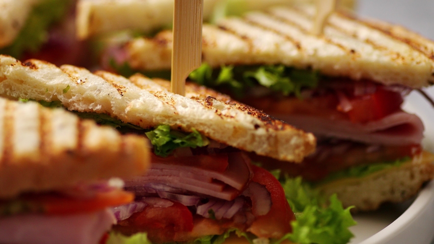 Close up on appetizing fresh and healthy grilled club sandwiches with ham and cheese | Shutterstock HD Video #1066765033