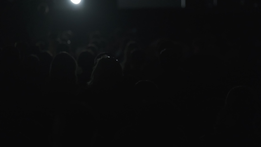 Audience silhouettes in beams of changing stage light | Shutterstock HD Video #1066768900