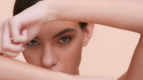 Beauty model touches her hand skin with a finger and looking through all this at the camera | Perfect skin and skin care concept