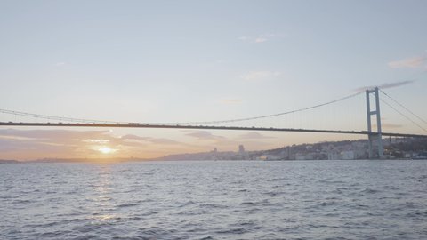 Beautiful view of long bridge over sea. Action. Hanging bridge over Bosphorus Strait on background of coast of Istanbul. Famous Bosphorus Bridge on sunny day
