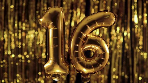 Golden number 16 sixteen, made from an inflatable balloon, on a yellow background. One of the complete set of numbers. The concept of birthday, anniversary, date