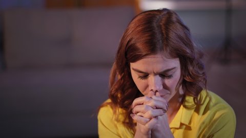 portrait of praying woman with faith and love in her heart with folded hands in room before going to bed at night, Christianity
