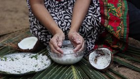 Woman making homemade fresh thick coconut milk with grated coconut, squeezing with hand 4K slow motion video Kerala India , in Indian Kitchen. ingredient in Indian curry. vegan non dairy health drink.