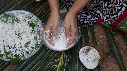 Woman making homemade fresh thick coconut milk with grated coconut, squeezing with hand 4K slow motion video Kerala India , in Indian Kitchen. ingredient in Indian curry. vegan non dairy health drink.