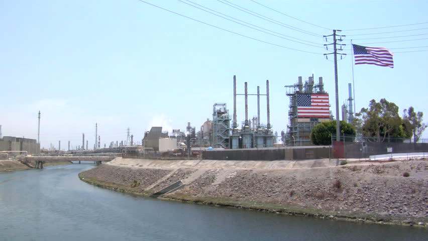 This is the American flag flying in front of an oil refinery.