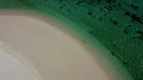Aerial Top View on Beautiful Blue Ocean on Beach with White Sand. Drone Shot of Amazing Landscape with Green Sea Water with Many Corals. Bird's Eye View Clear Crystal Ocean Water an Empty Sand Beach