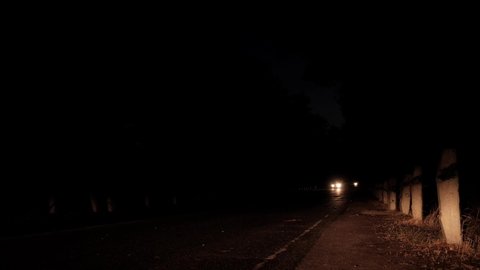 The headlights of the car are shining. Car on the road at night