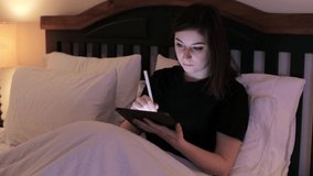 Young brunette woman working from home in bed with tablet drinking coffee. HD 24FPS.