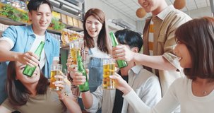 slow motion of asian six friends watch ball games on tv and toasting beer in the restaurant
