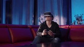 Technology fascination, young man in a living room at night, playing VR games. Online world, virtual reality fun. Futuristic heeadset, gaming and esports. Innovation for everyday life.
