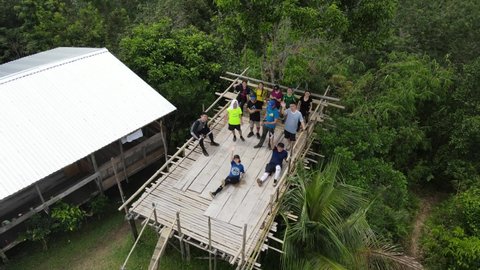 Kuching, Sarawak – Dec 19, 2020: The image showing that a group of teenagers are excited to do adventure  hiking and reach the top mountain village of tropical rainforest of Sarawak, Malaysia, Asia.