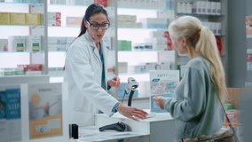 Pharmacy Drugstore Checkout Cashier Counter: Female Pharmacist Explains Use and Manual for Prescription Medicine Beautiful Senior Female Customer Paying Using Contactless Credit Card to Terminal - Powered by Shutterstock - Get 15% off with code: PIKWIZARD15