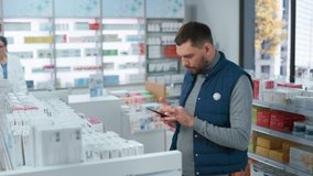 Pharmacy Drugstore: Portrait of Handsome Young Caucasian Man Using Smartphone, Searching to Purchase Best Medicine, Drugs, Vitamins. Shelves full of Health Care, Wellness, Sports Supplements - Powered by Shutterstock - Get 15% off with code: PIKWIZARD15