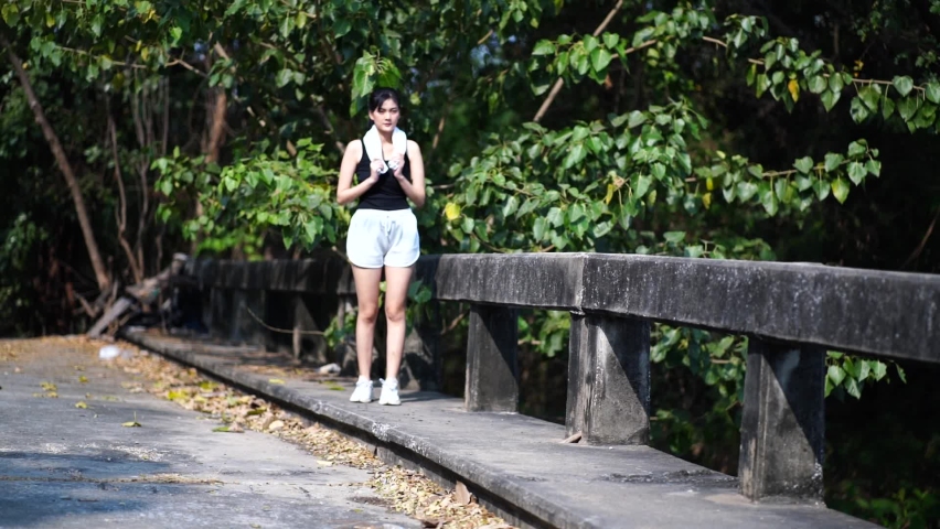 beautiful woman wearing sportswear after running and stretching her limbs to relieve back pain in the evening garden. Sports and health concept 