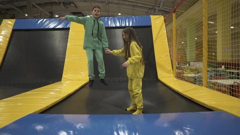 Active leisure. Children having fun on trampoline in entertainment center, childhood and sporty lifestyle. Boy and girl in leisure spotr center for kids. Brother and sister indulge on trampolines.