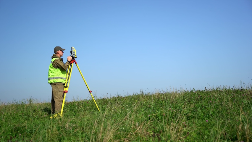 Professional engineer surveyor takes measures with tacheometer. Royalty-Free Stock Footage #1066862053
