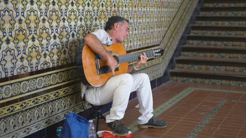 SEVILLA, SPAIN - 11TH AUGUST 2019:  the man play guitar on the Plaza de España, Sevilla, Spain, Europe.
