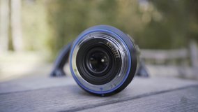 Close up of professional camera lens lying on a rotating children roundabout. Action. Photography concept. forgotten camera lens outdoors on blurred background. 