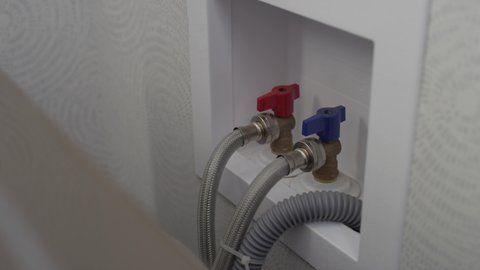 Turning off the water supply to a washing machine before disconnecting the hoses