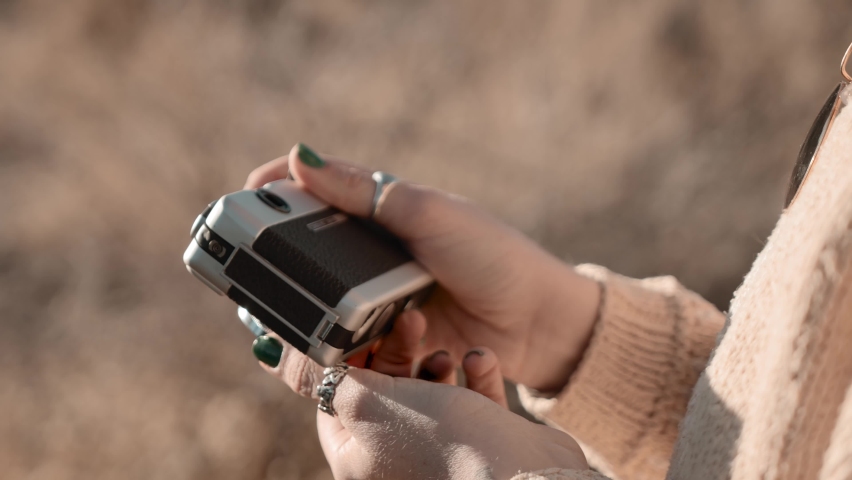 girl takes a picture with a vintage camera in california desert