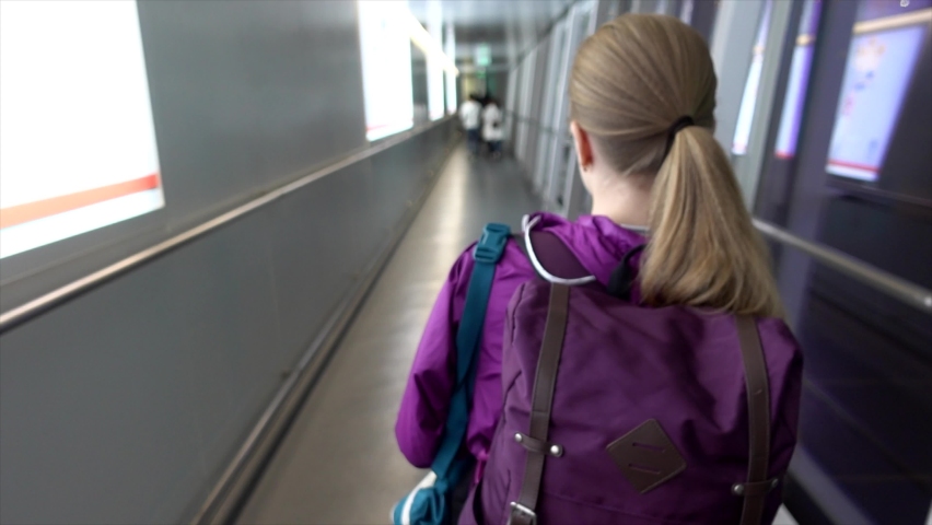 A young girl walks down the hallway to the plane
