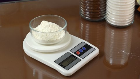  Flour on scales. Weigh flour on digital kitchen kitchen. High 4k quality 4k footage. Cooking in kitchen. 