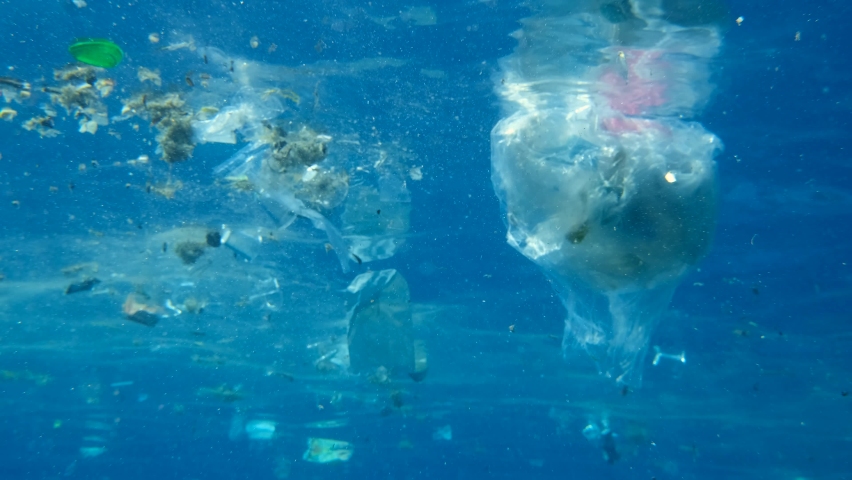 Slow motion, Massive plastic and other debris slowly drifts under surface of the blue ocean in the sunrays. Plastics garbage environmental pollution problem. Massive plastic pollution of the Ocean | Shutterstock HD Video #1066895971