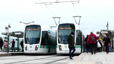 Paris, France. January 24. 2021. Tram crossing in the Bercy district. People getting on and off a wagon in a station. Passengers travelling by public transport.