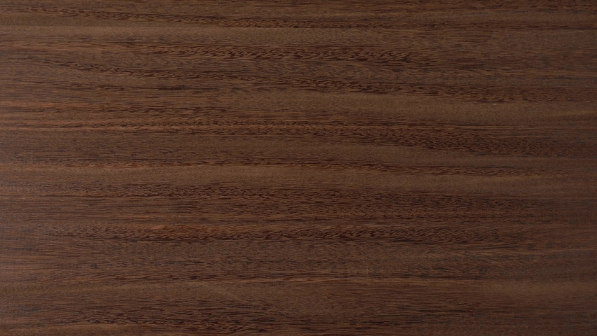 Top view flatlay 4k stock video footage of brown wooden background and collection of old vintage black and white photographs with copy space in middle of frame